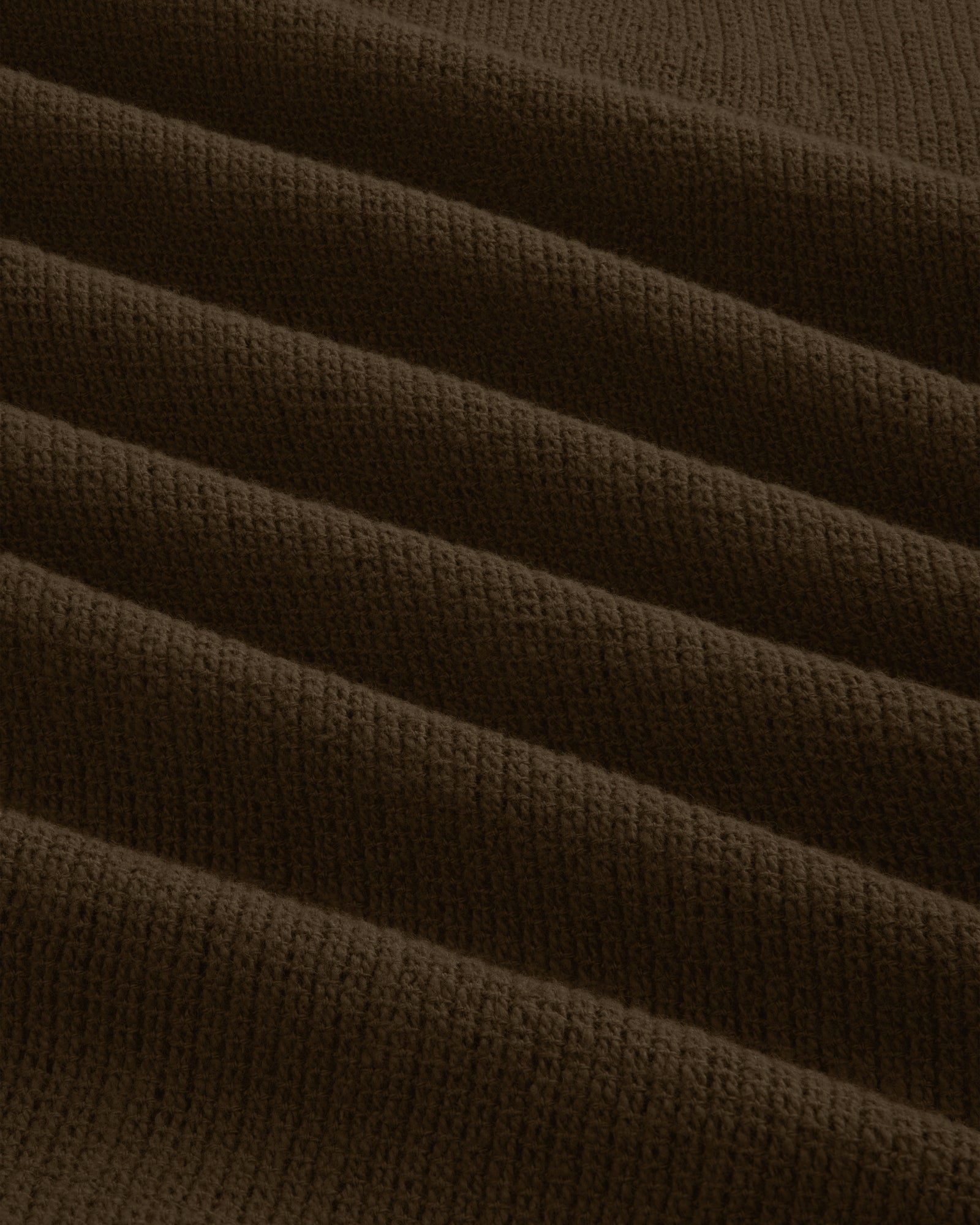 Close-up of the Mesh Jungle Shirt's brown, ribbed knit fabric with textured, evenly spaced horizontal folds.