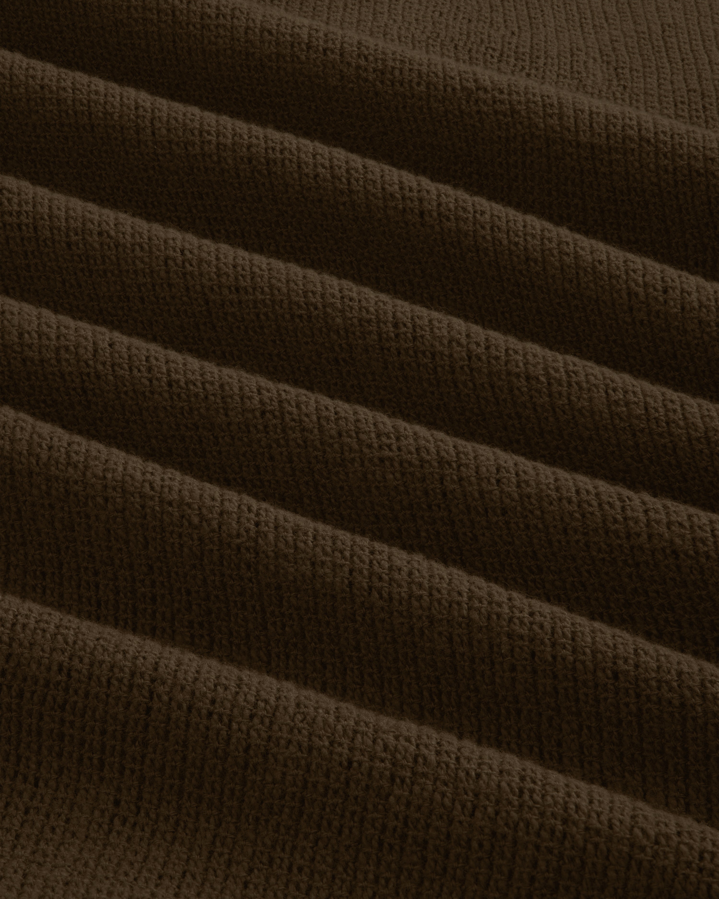 Close-up of the Mesh Jungle Shirt's brown, ribbed knit fabric with textured, evenly spaced horizontal folds.