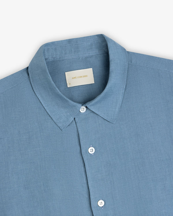 Light blue Long-Sleeve Linen Shirt with a pointed collar, white buttons, and visible neck label on plain background.