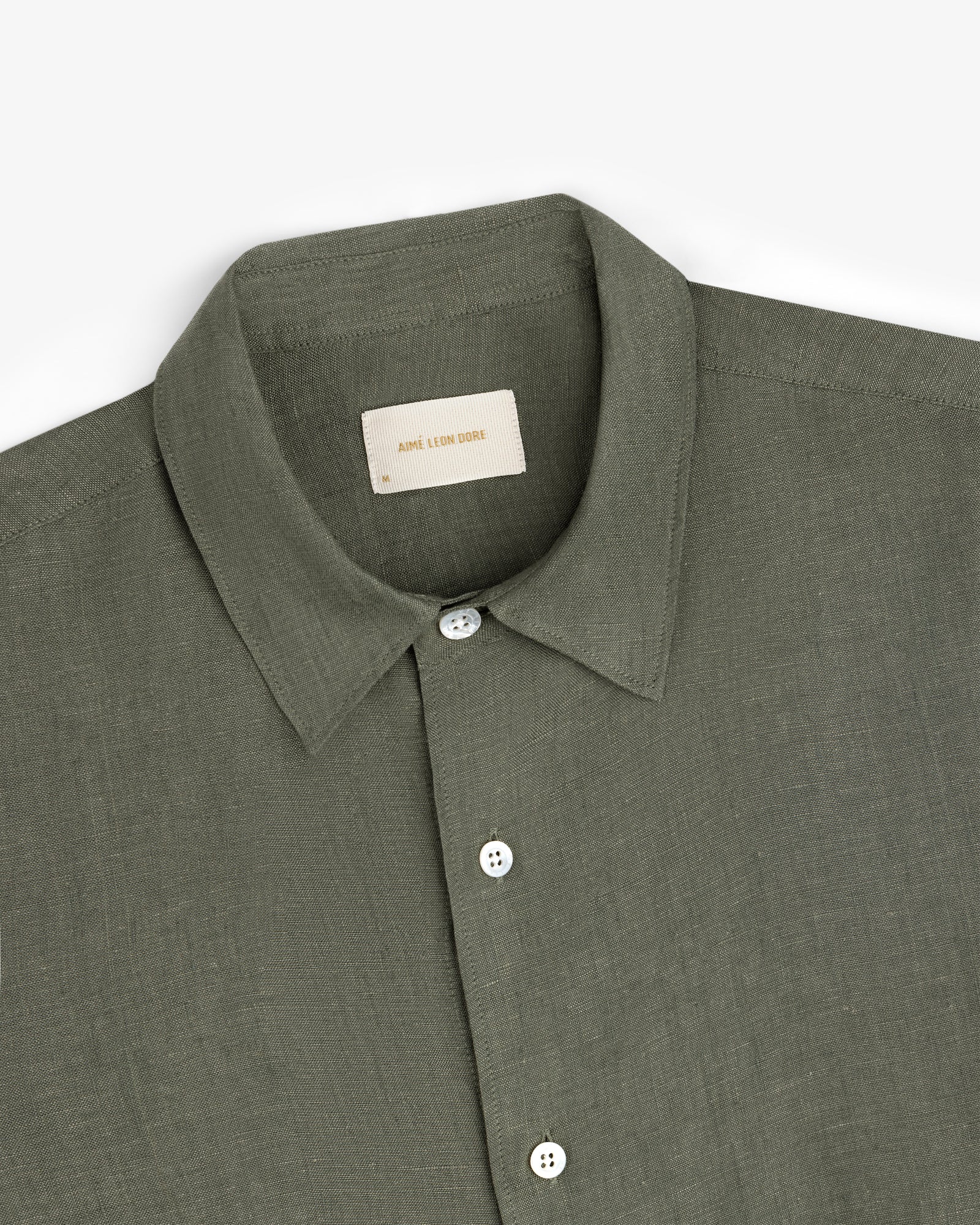 Olive green Long-Sleeve Linen Shirt with white buttons, folded on a white background.