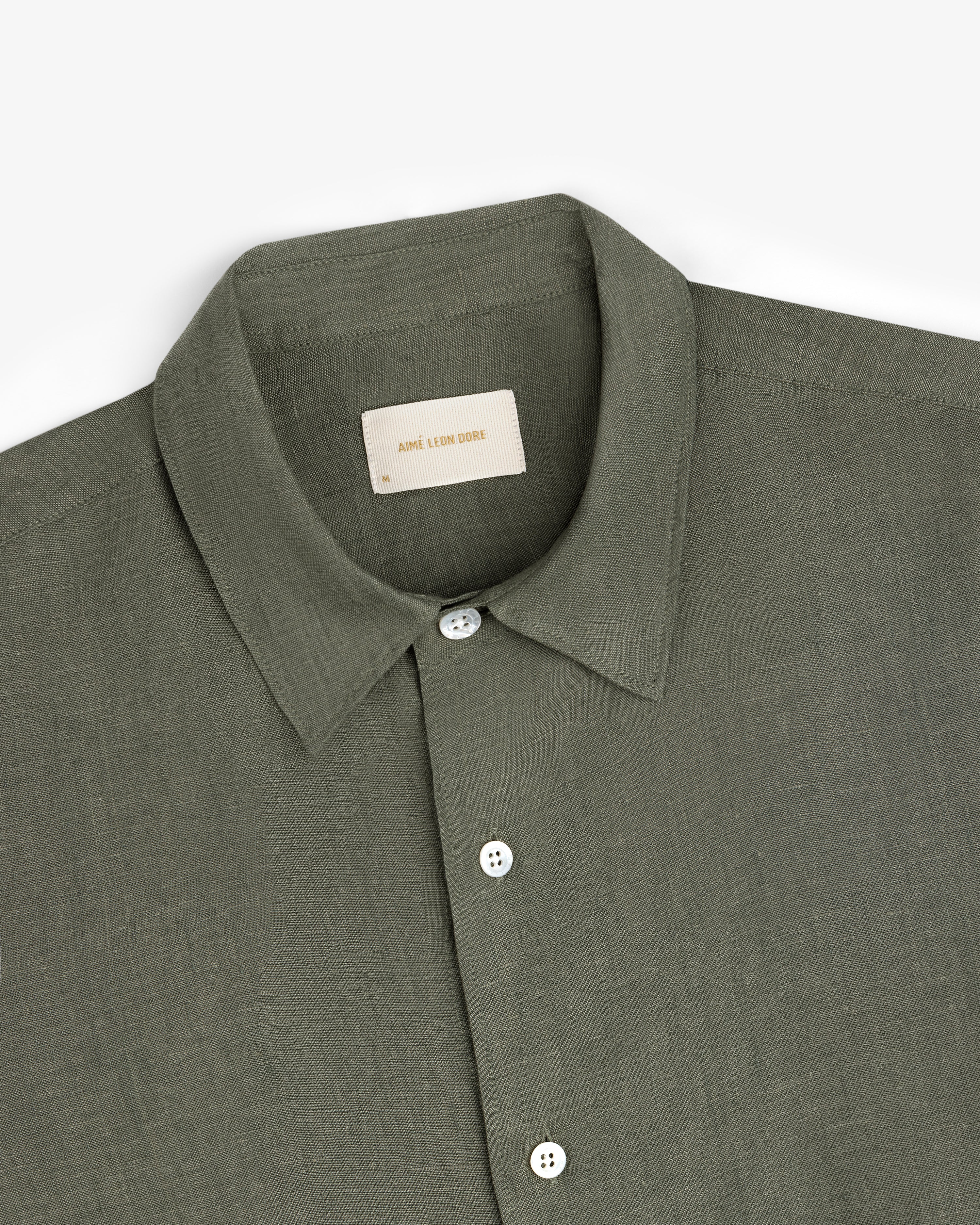 Olive green Long-Sleeve Linen Shirt with white buttons, folded on a white background.