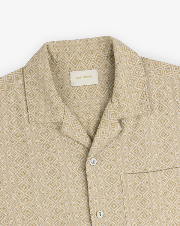 Jacquard Leisure Shirt—beige with geometric pattern, collar, chest pocket, and white buttons on a flat white background.