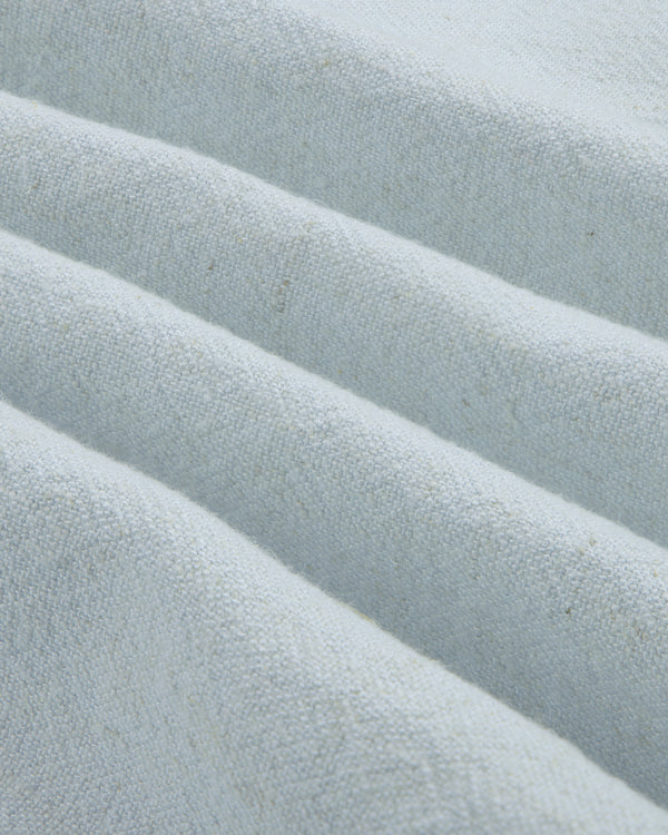 Close-up of the Linen Blend Leisure Shirt's textured light gray fabric with soft diagonal folds.