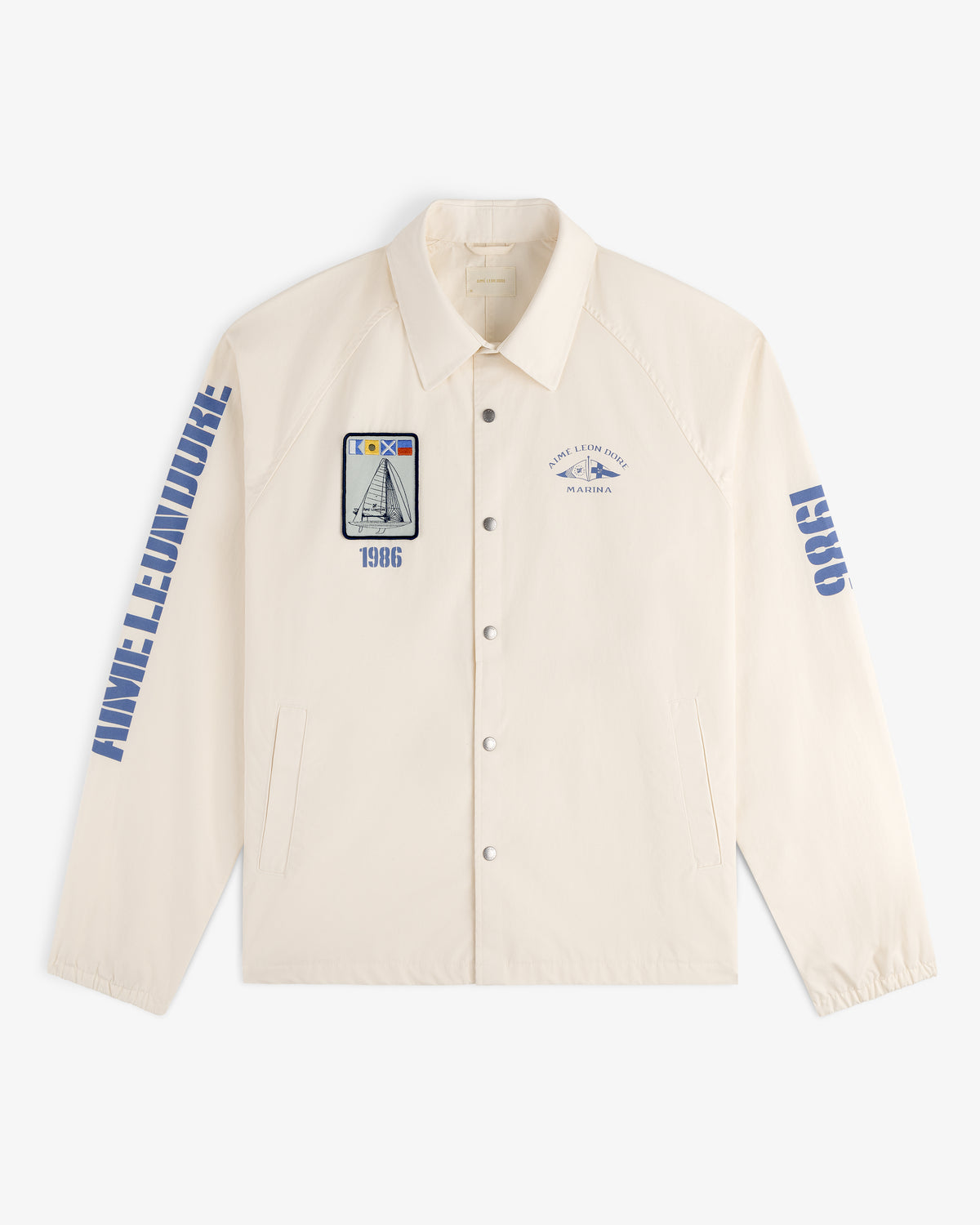 Marina Jacket: Beige button-up with blue graphics, ANNE LEMOINE on the sleeve, and nautical-themed patches.