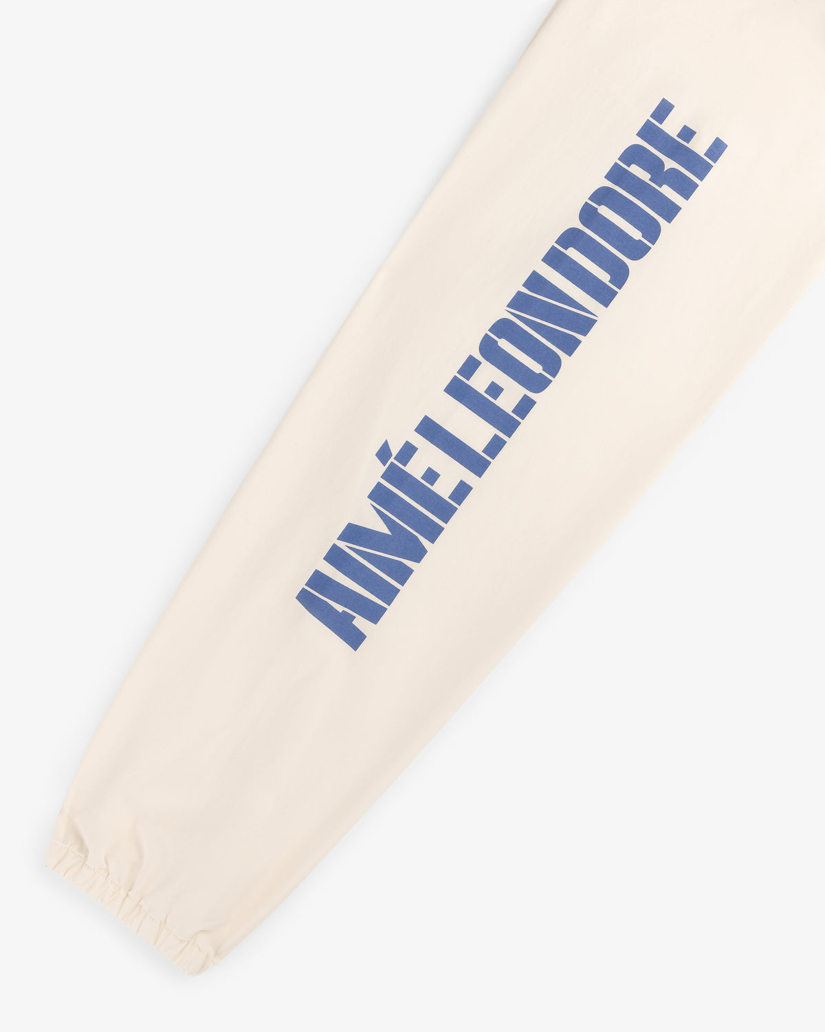 Cream-colored Marina Jacket sleeve with large blue AIMÉ LEON DORE print and an elastic cuff at the wrist.