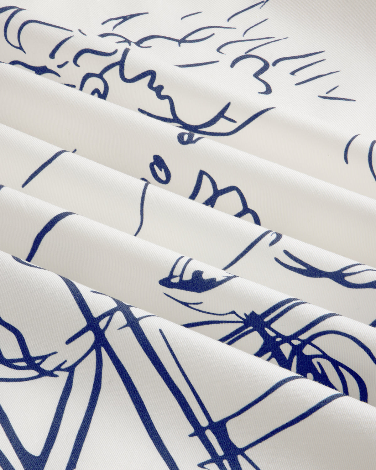 Fassianos "Rendez-Vous" Camp Shirt: white fabric with blue abstract face line art, draped in soft folds.