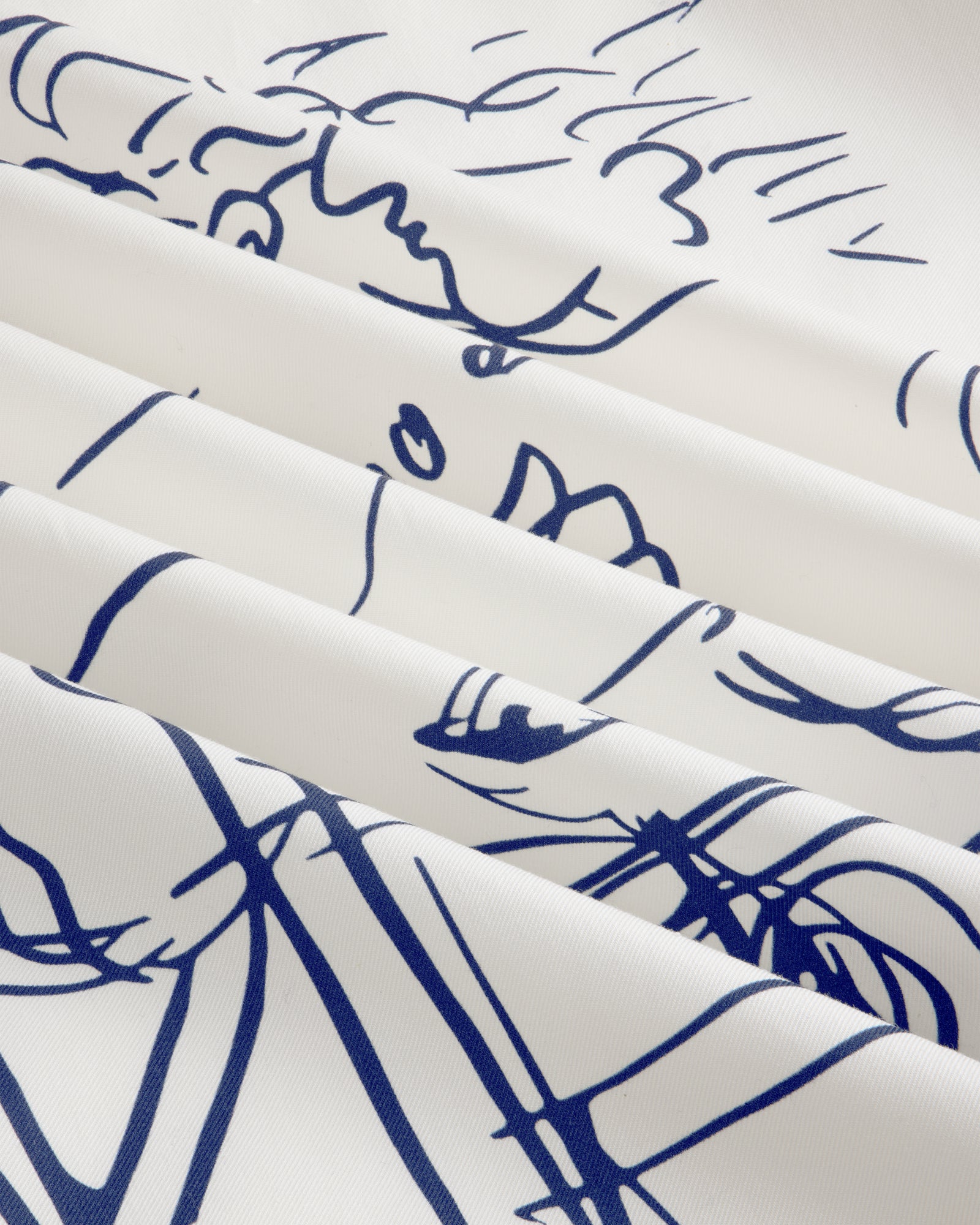 Fassianos "Rendez-Vous" Camp Shirt: white fabric with blue abstract face line art, draped in soft folds.