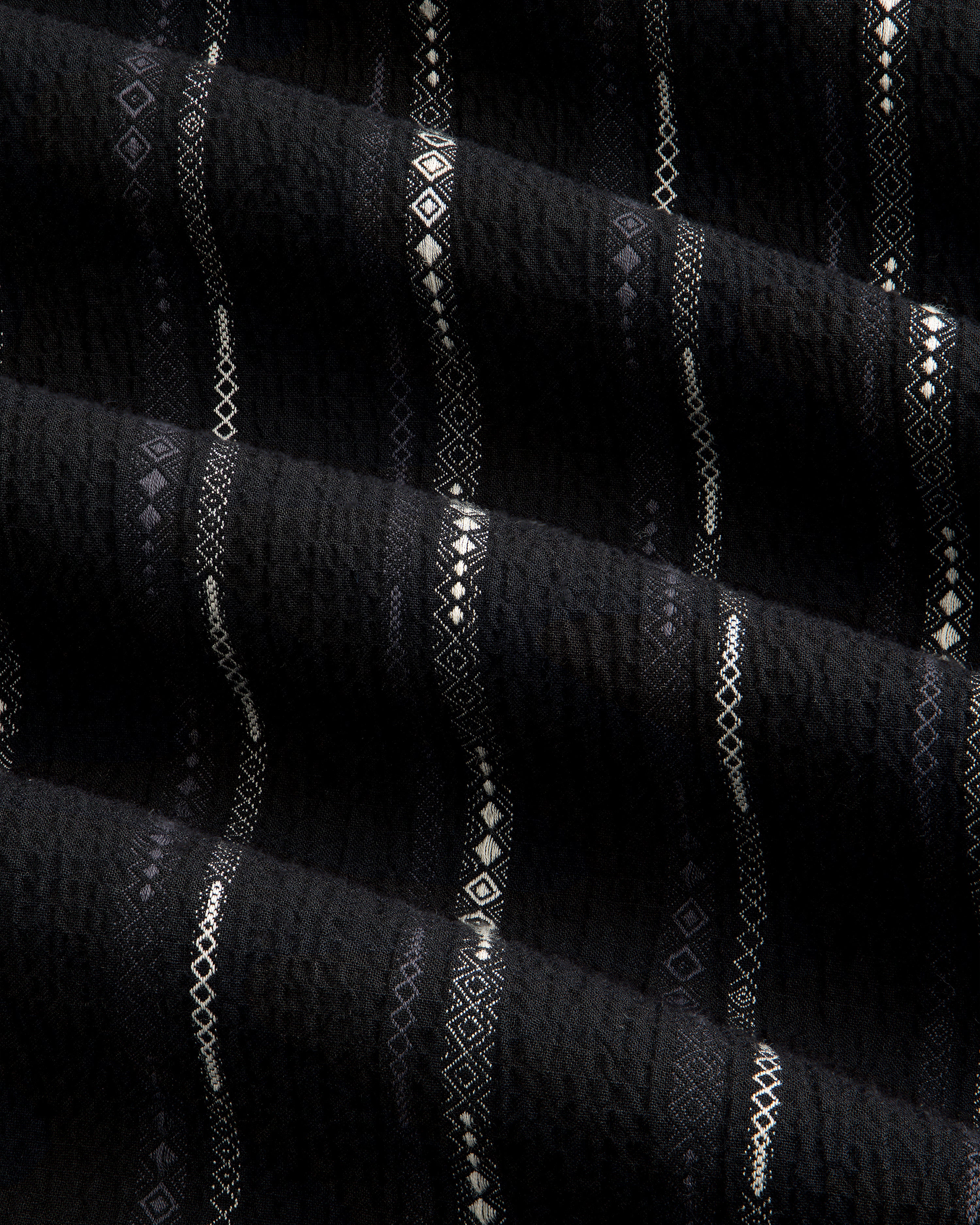 Close-up of black Cropped Jacquard Camp Shirt featuring vertical stripes and geometric patterns in white and gray.