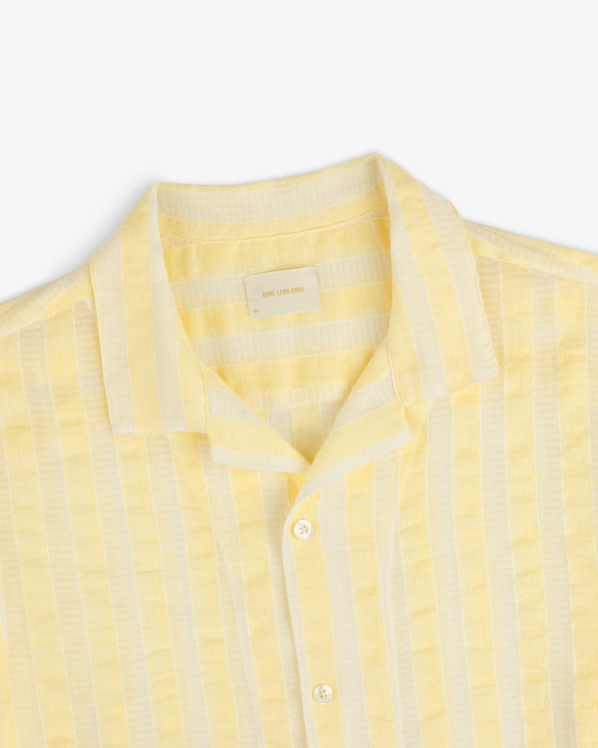Linen Blend Striped Camp Shirt in yellow and white vertical stripes, shown from the shoulders up on white background.