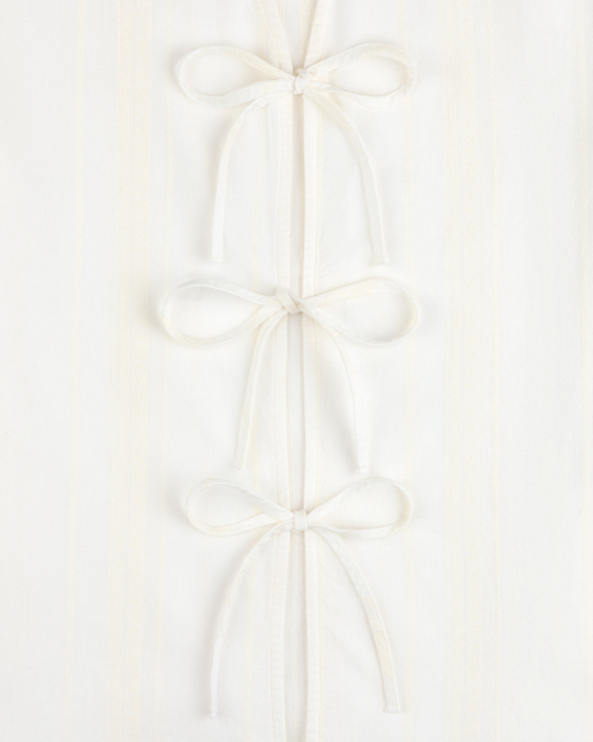 Jacquard Striped Tie-Front Shirt in white, featuring three fabric bows on a subtly striped background.