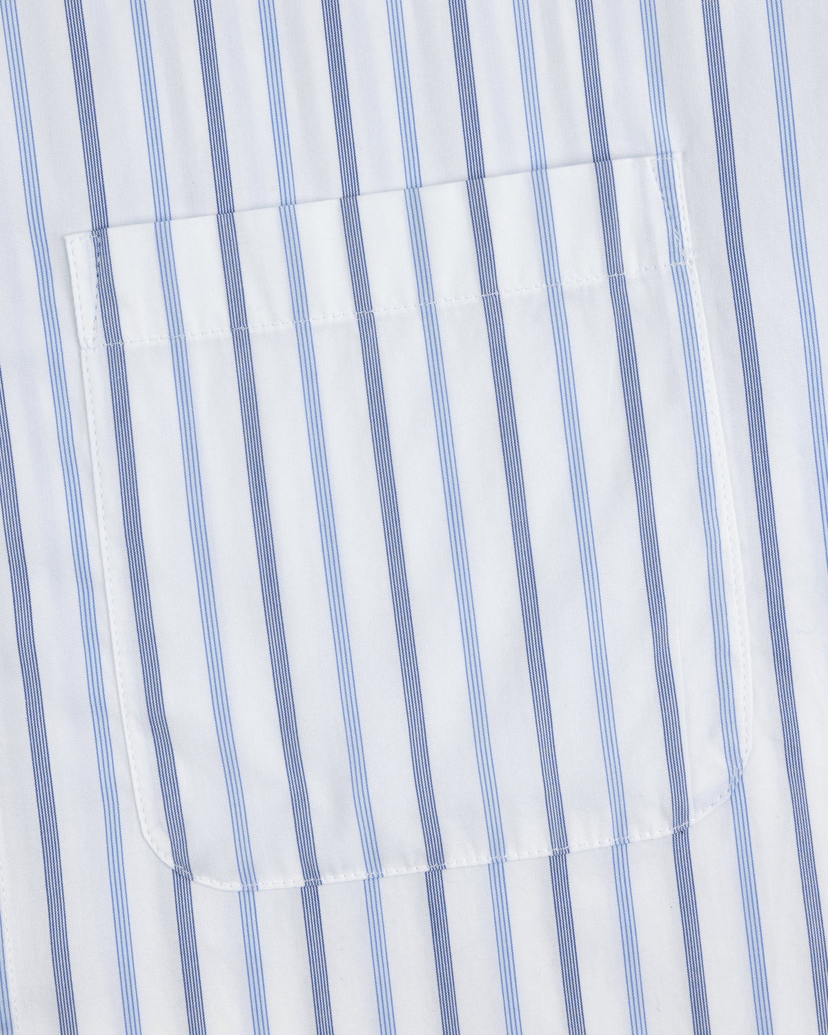 A close-up of the pocket on a Poplin Casual Shirt with vertical blue and light blue stripes on white fabric.