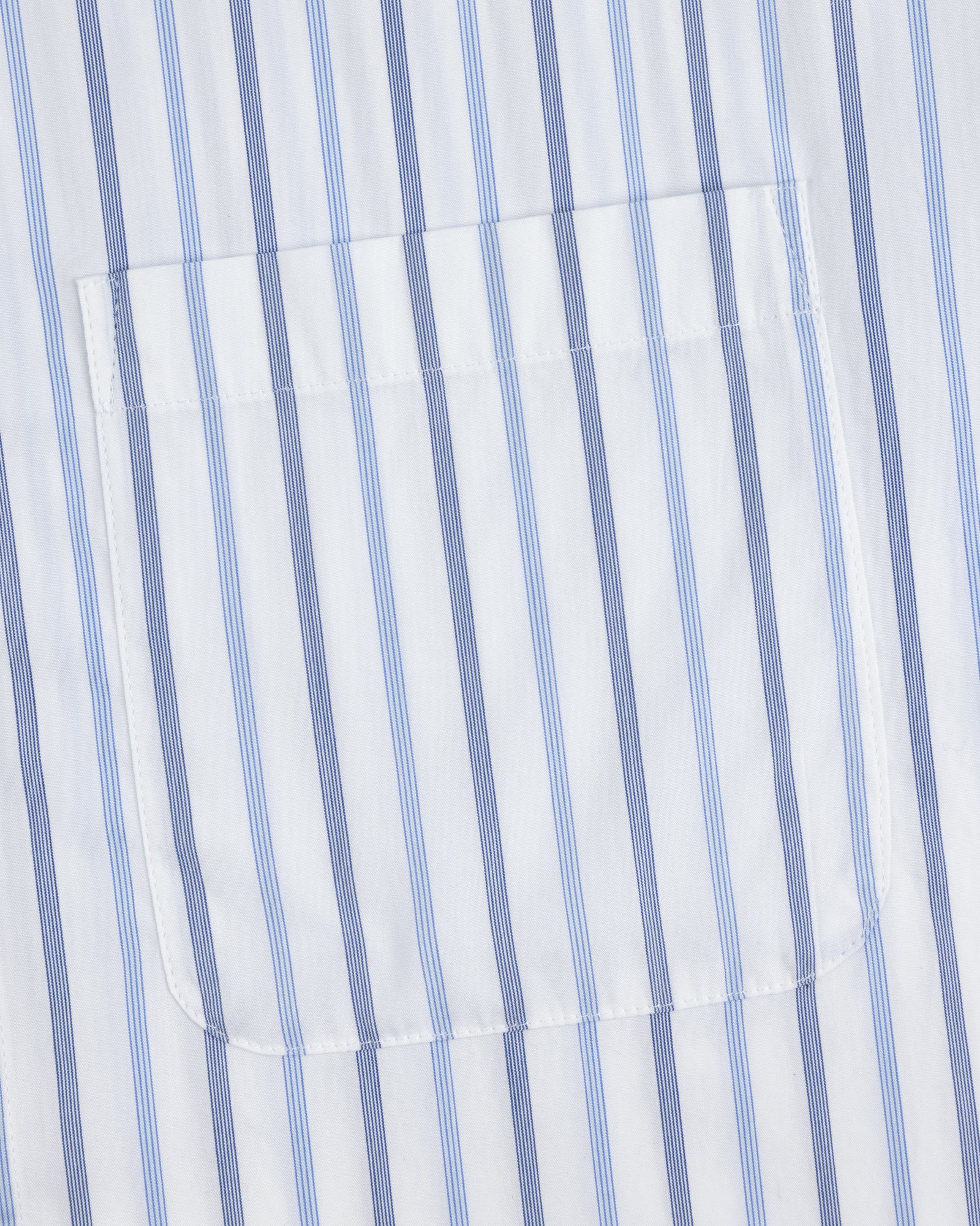 A close-up of the pocket on a Poplin Casual Shirt with vertical blue and light blue stripes on white fabric.