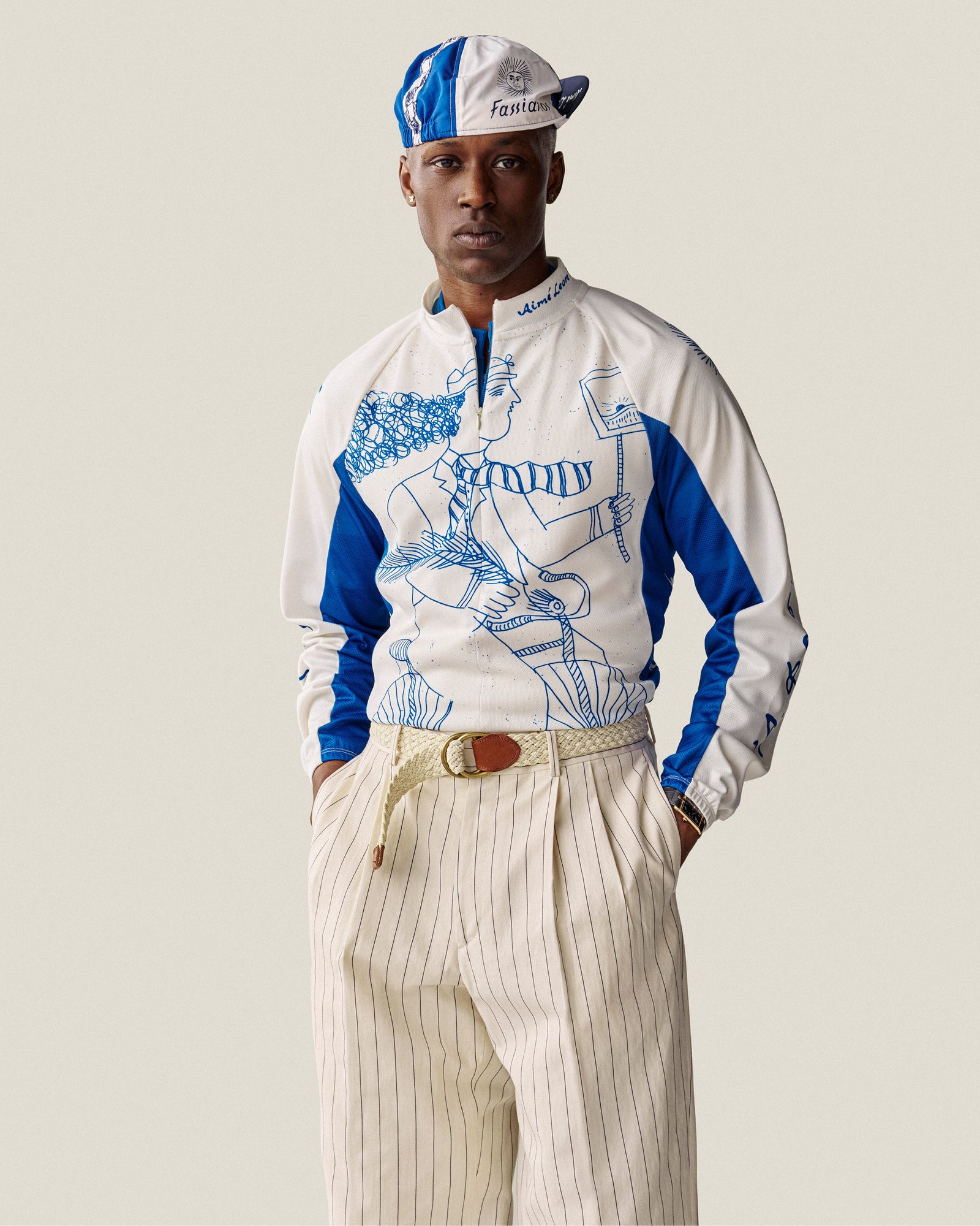 Man in Fassianos Half-Zip Cycling Jersey and pleated pinstripe trousers, hands in pockets.