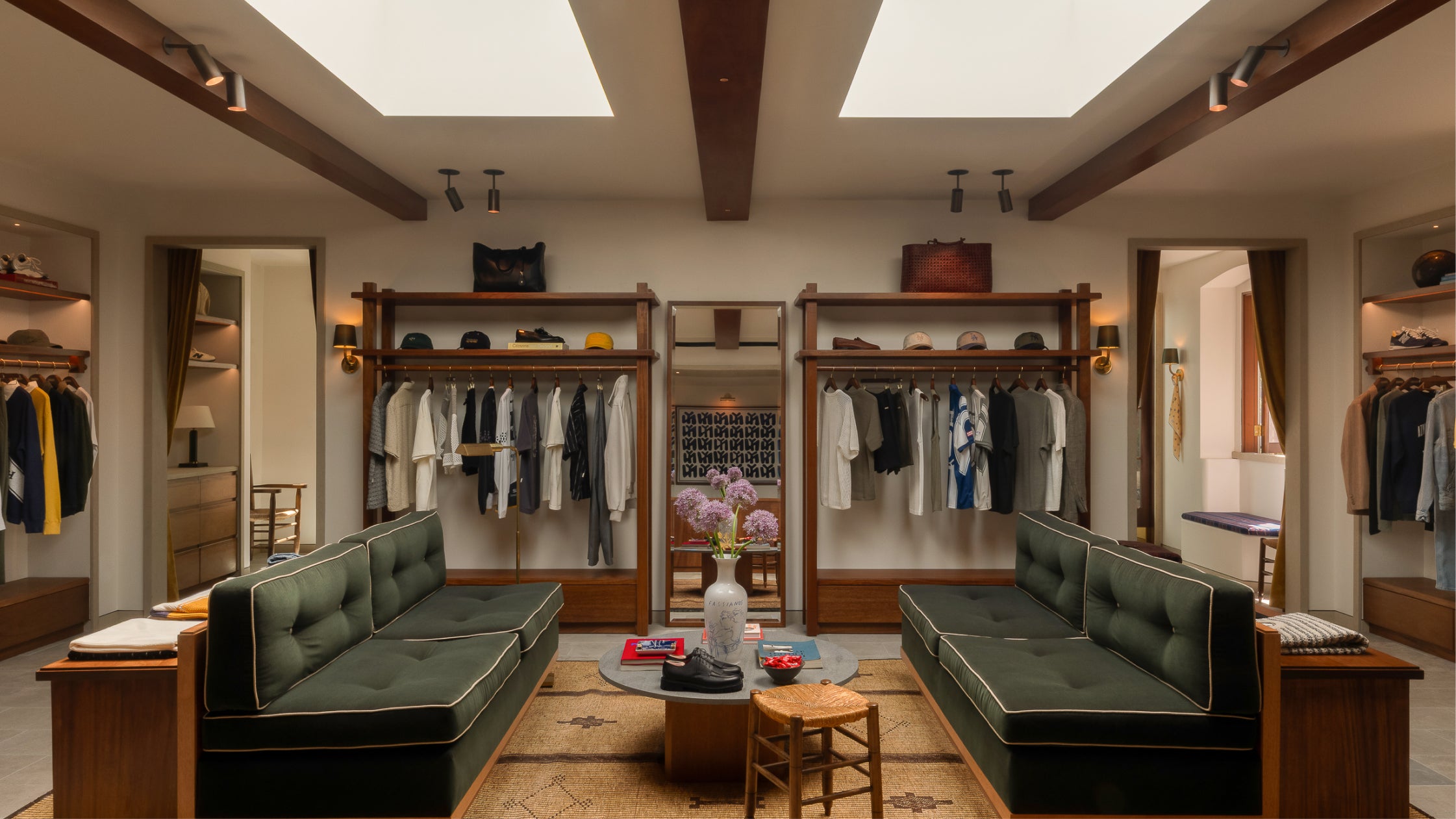 Interior of Los Angeles flagship- green sofas, wooden floors, and clothing racks.