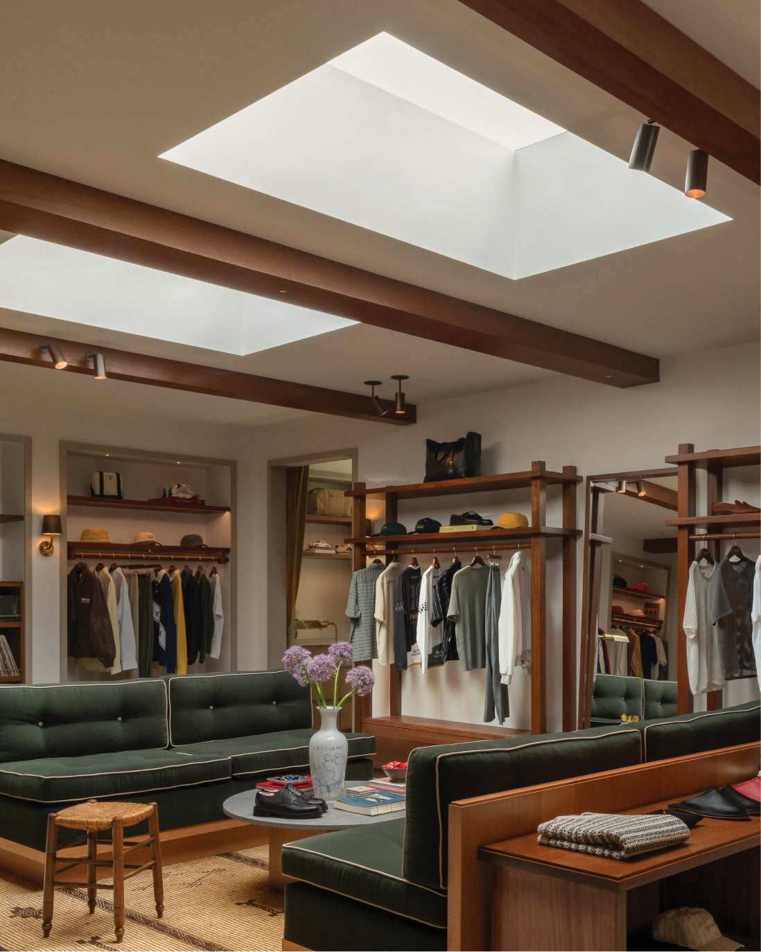 Interior of Los Angeles Flagship- green sofas, wooden racks, and ceiling lights.
