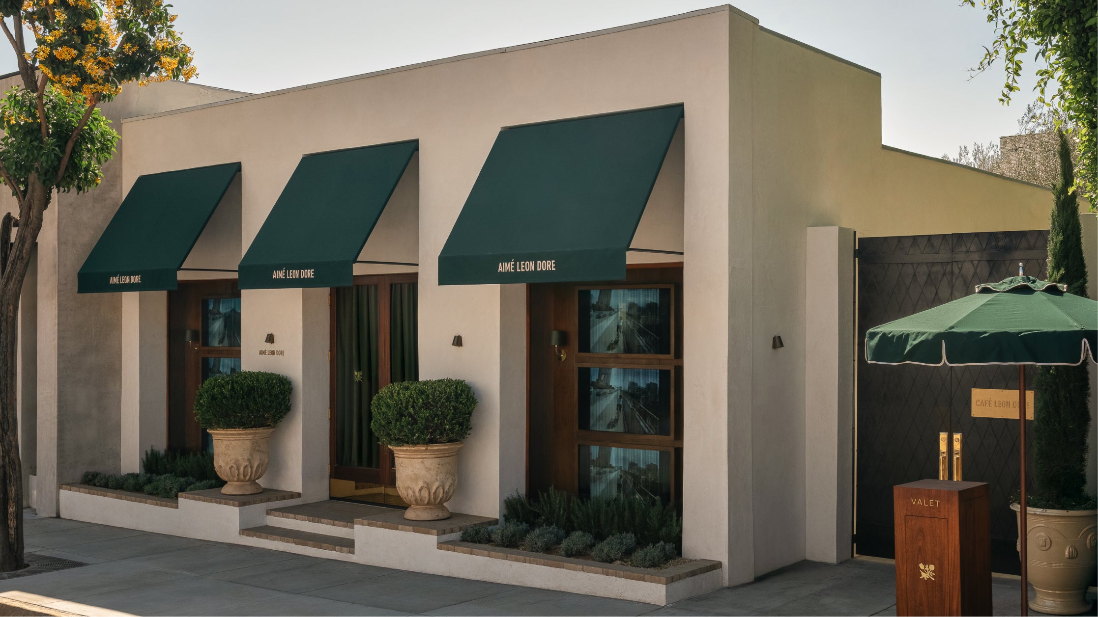 Exterior of the Los Angeles flagship with green awnings and outdoor furniture
