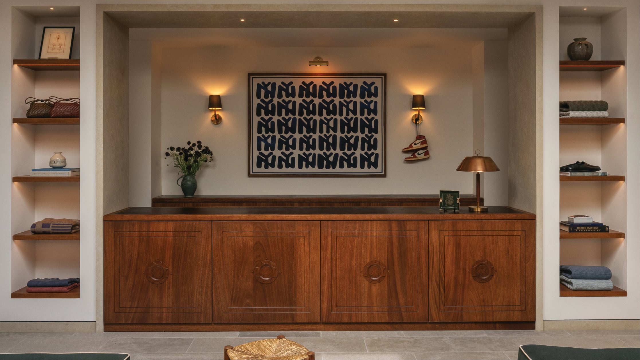 Checkout area at Los Angeles flagship-Wooden cabinet with decorative elements in a room with shelves and wall art.