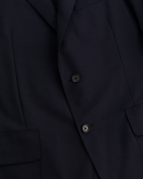 Close-up of the Tropical Wool Suit Jacket in dark navy with two black buttons and front flap pockets.