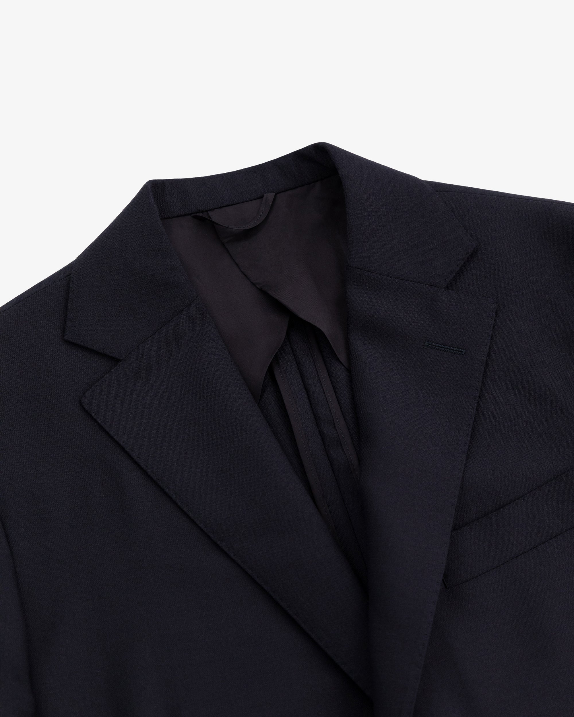 Close-up of the Tropical Wool Suit Jacket featuring a notched lapel and chest pocket on a white background.