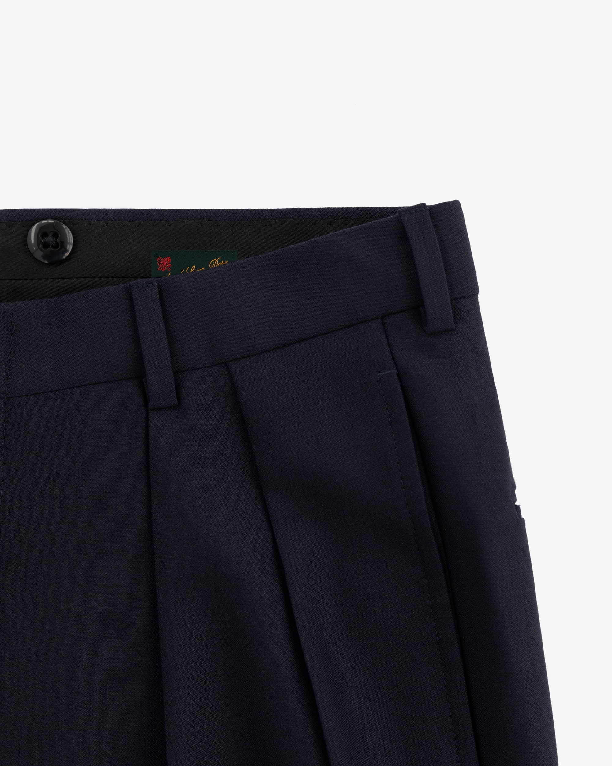 Close-up of the waist and upper leg of Tropical Wool Suit Trouser in navy with pleats, button, and belt loops.