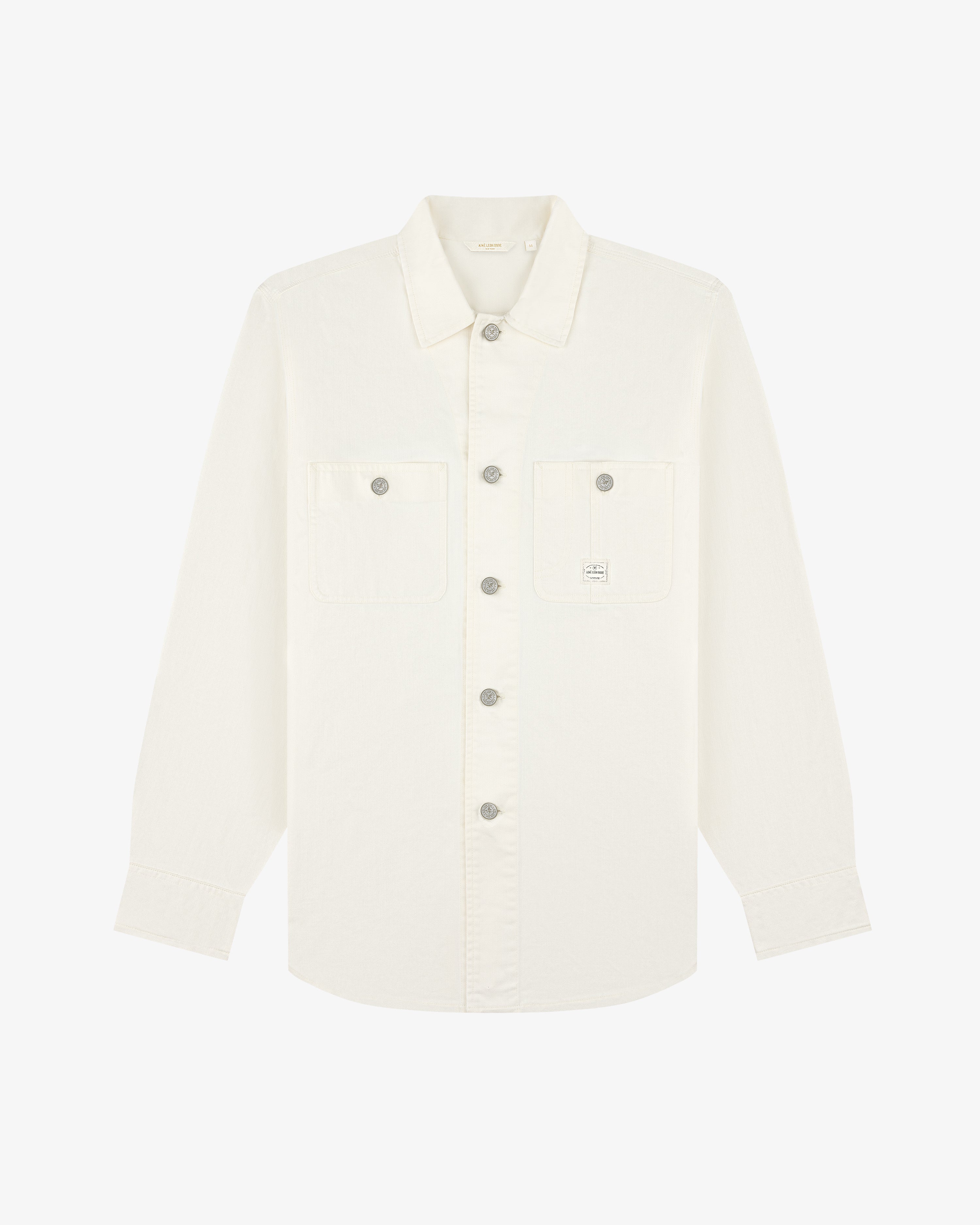Carpenter Overshirt: long-sleeve white button-up, two chest pockets, small logo on left pocket, laid flat.