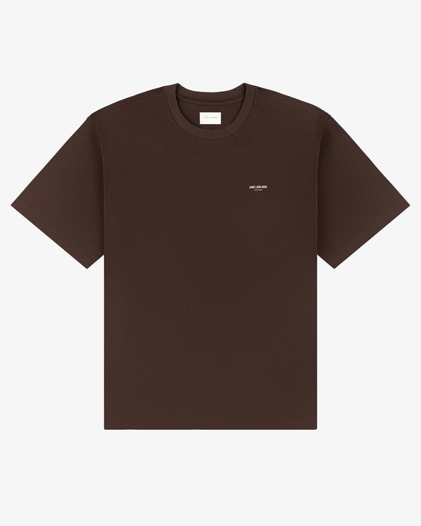 Micro Logo Tee in dark brown with a small white logo on the left chest, shown on a white background.