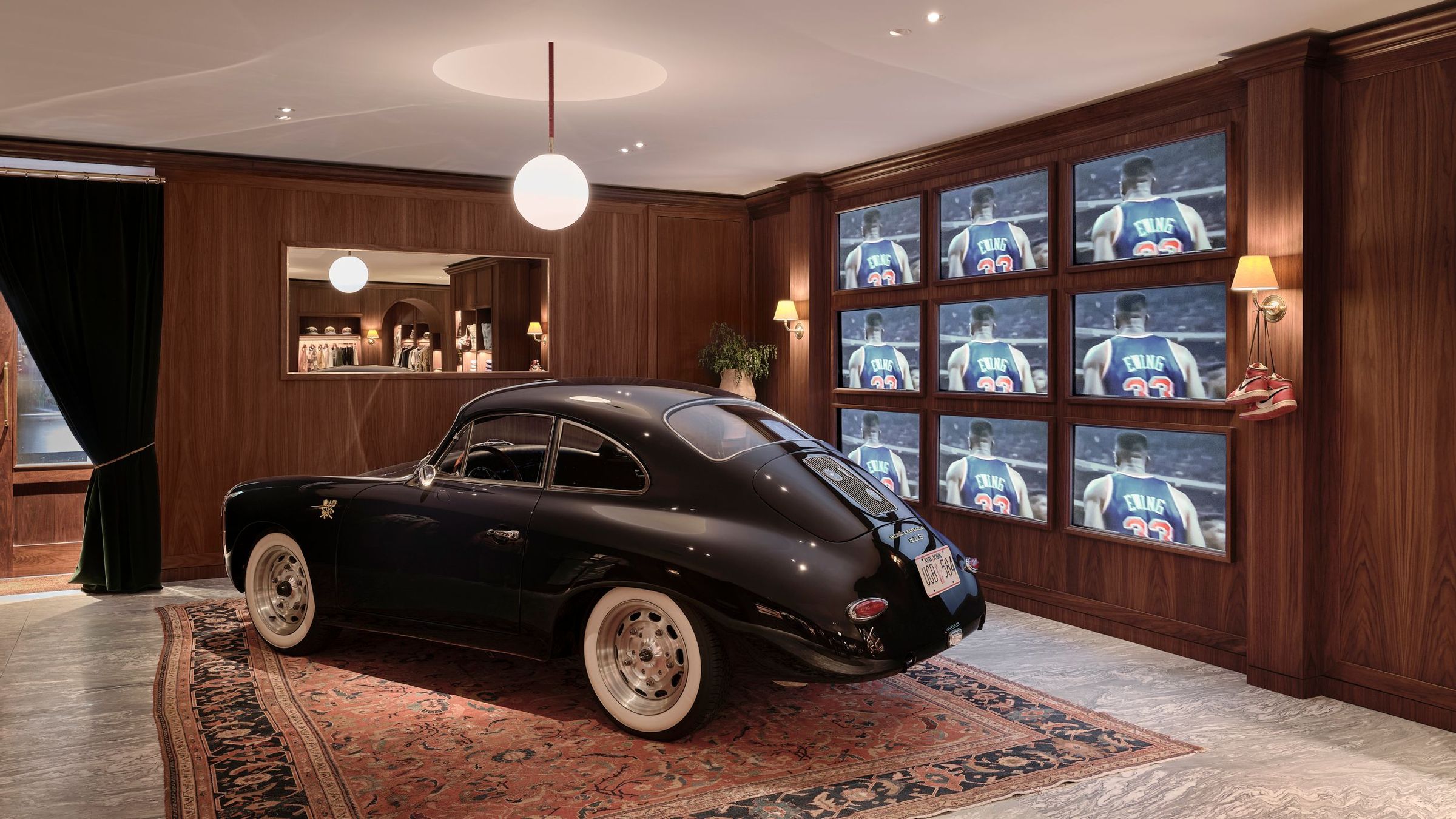 Car in interior of New York City flagship with 9 TV screens in background