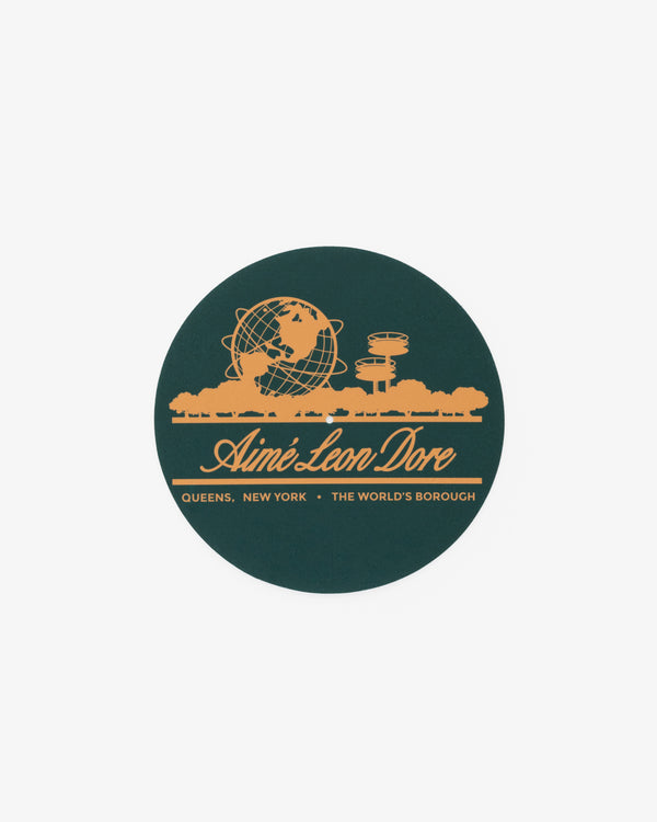 Unisphere Slip Mat featuring yellow Aimé Leon Dore logo and Queens, NY landmarks on a dark green background.