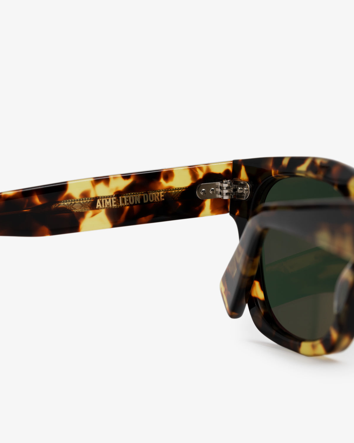 Close-up of Gallo Sunglasses with green lenses; AIME LEON DORE text on the inner arm.
