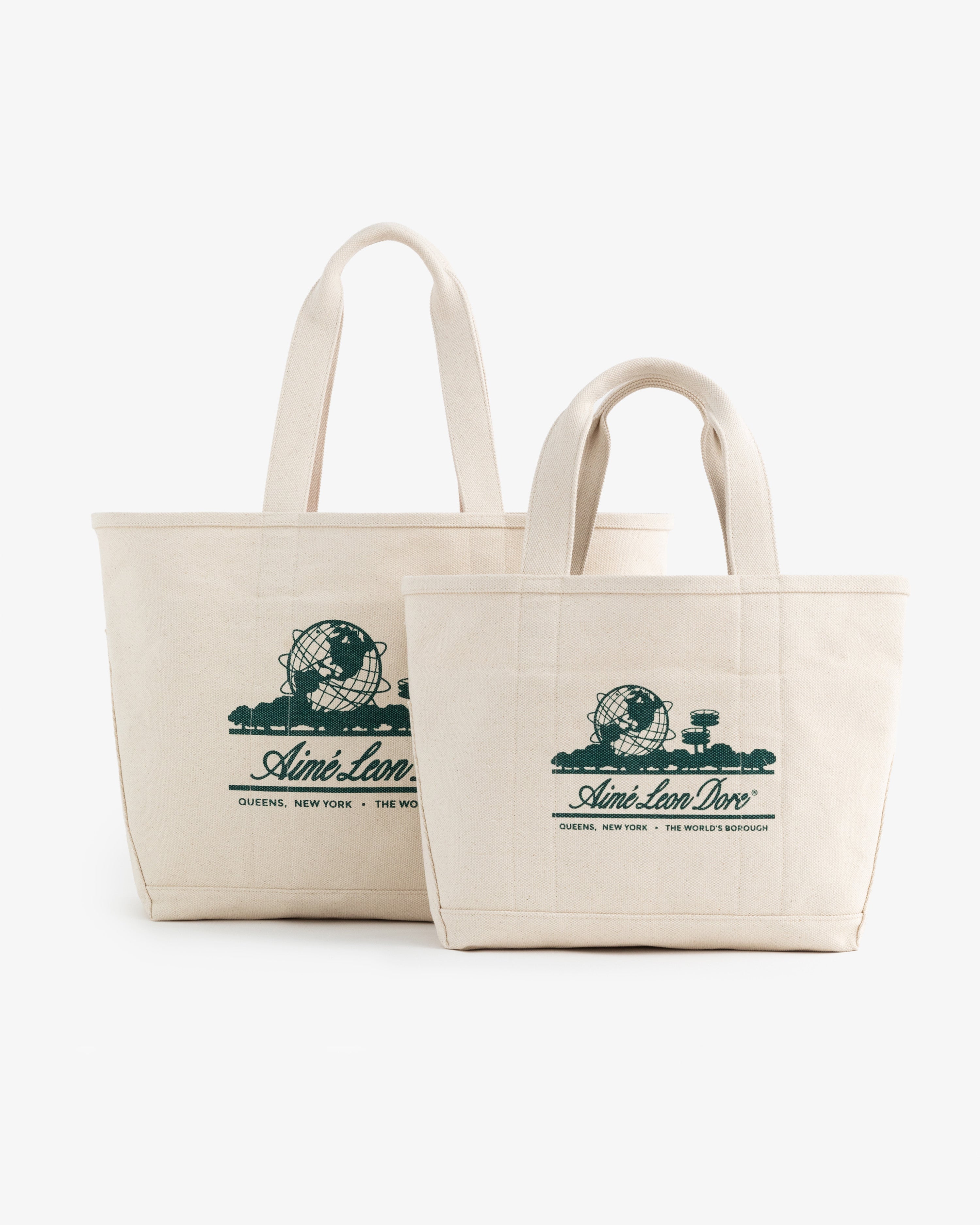 Two cream-colored Small Unisphere Tote Bags with green Aimé Leon Dore text and globe graphics.
