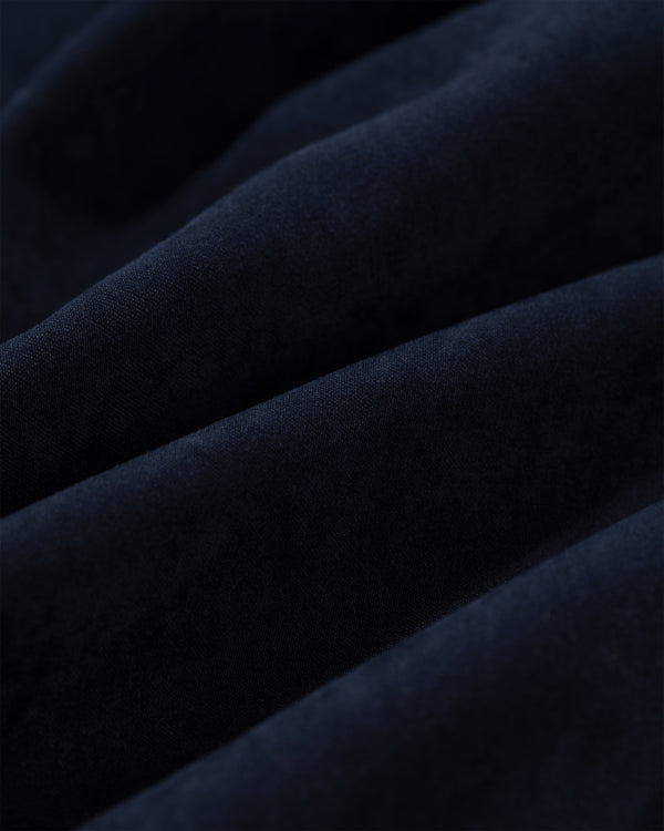 Close-up of Tropical Wool Elasticated Waist Suit Trouser in deep navy blue with soft, wavy folds and smooth texture.