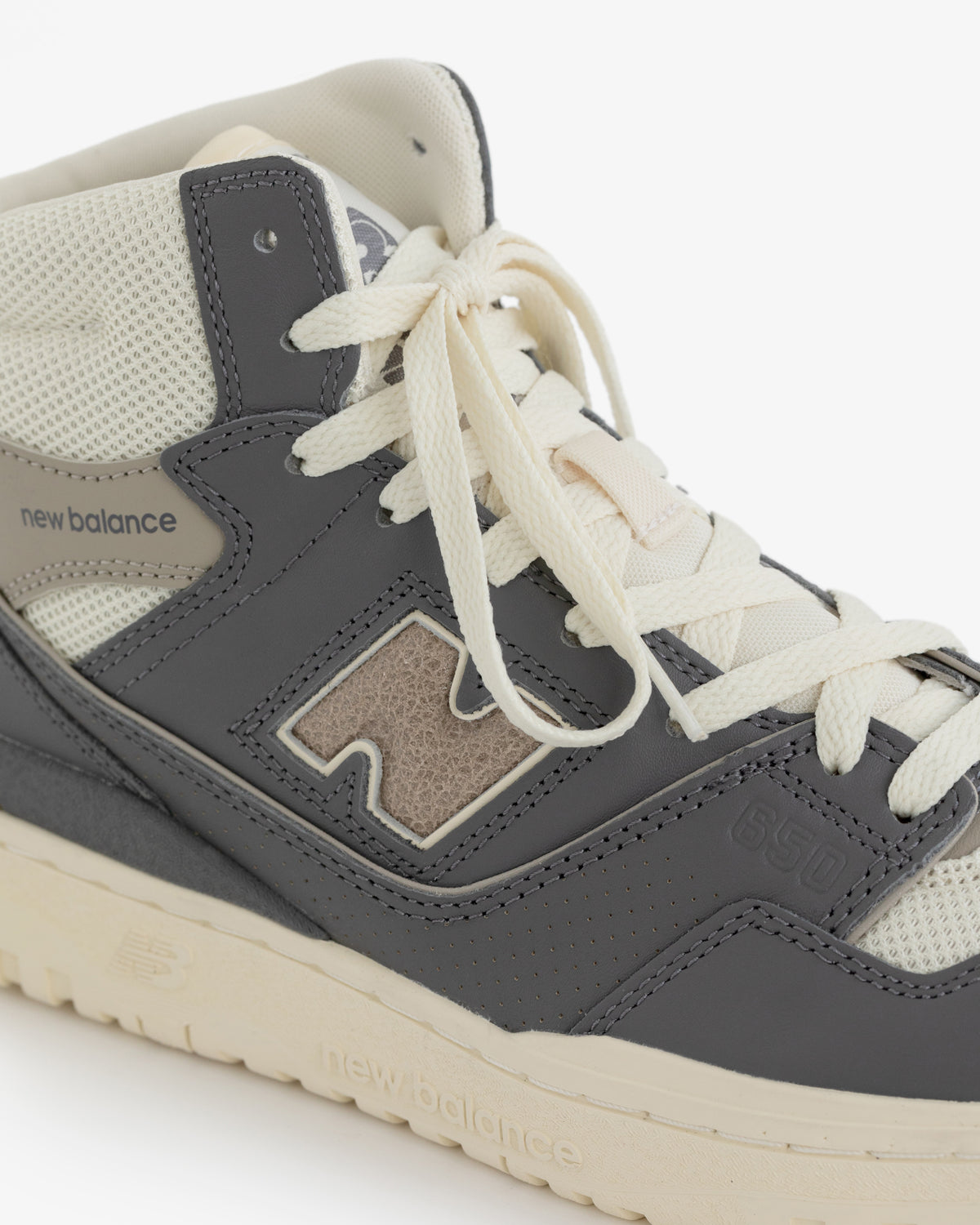 A close-up of the ALD / New Balance 650R in gray and beige with cream laces and mesh details.