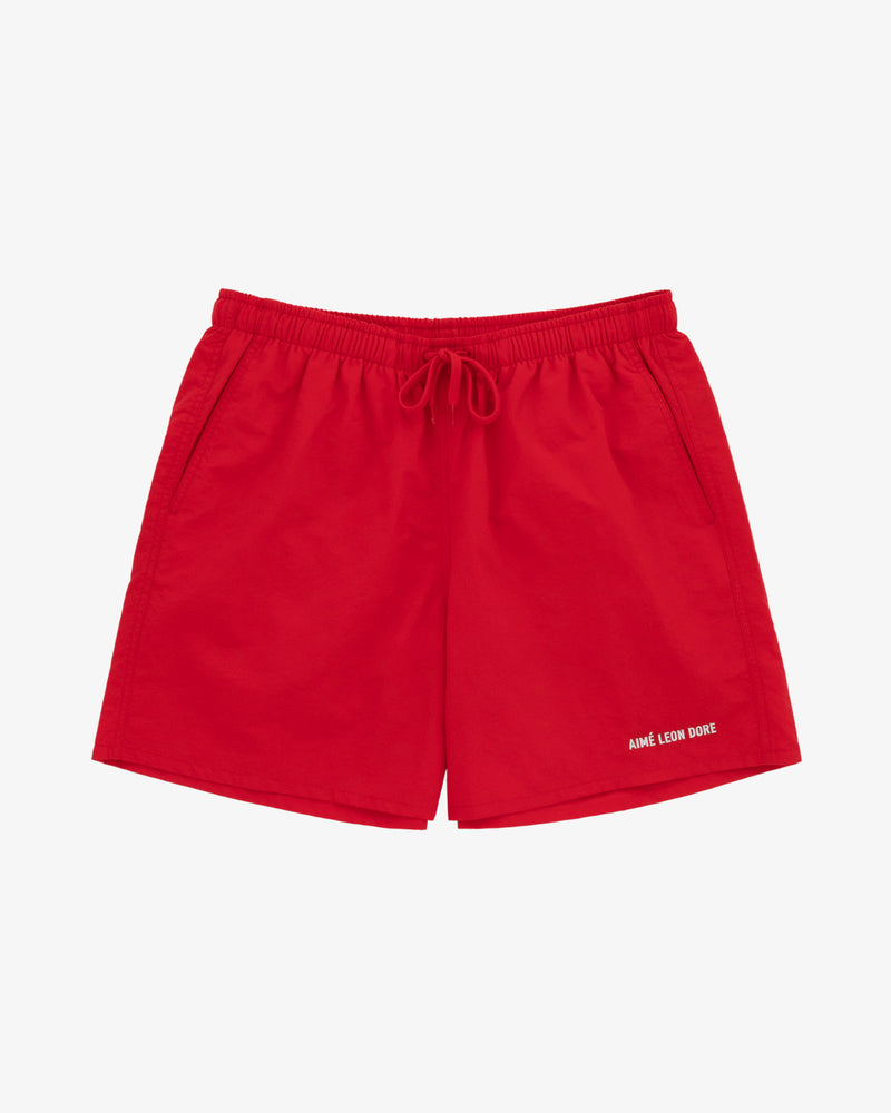 Bright red Logo Swim Shorts with side pockets and AIMÉ LEON DORE in white on the left leg.