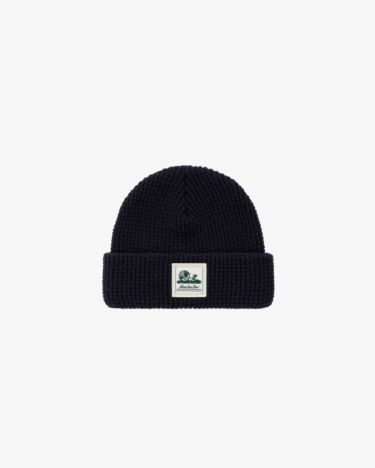 The Waffle Knit Beanie is black with a folded brim and a small logo patch on the front.