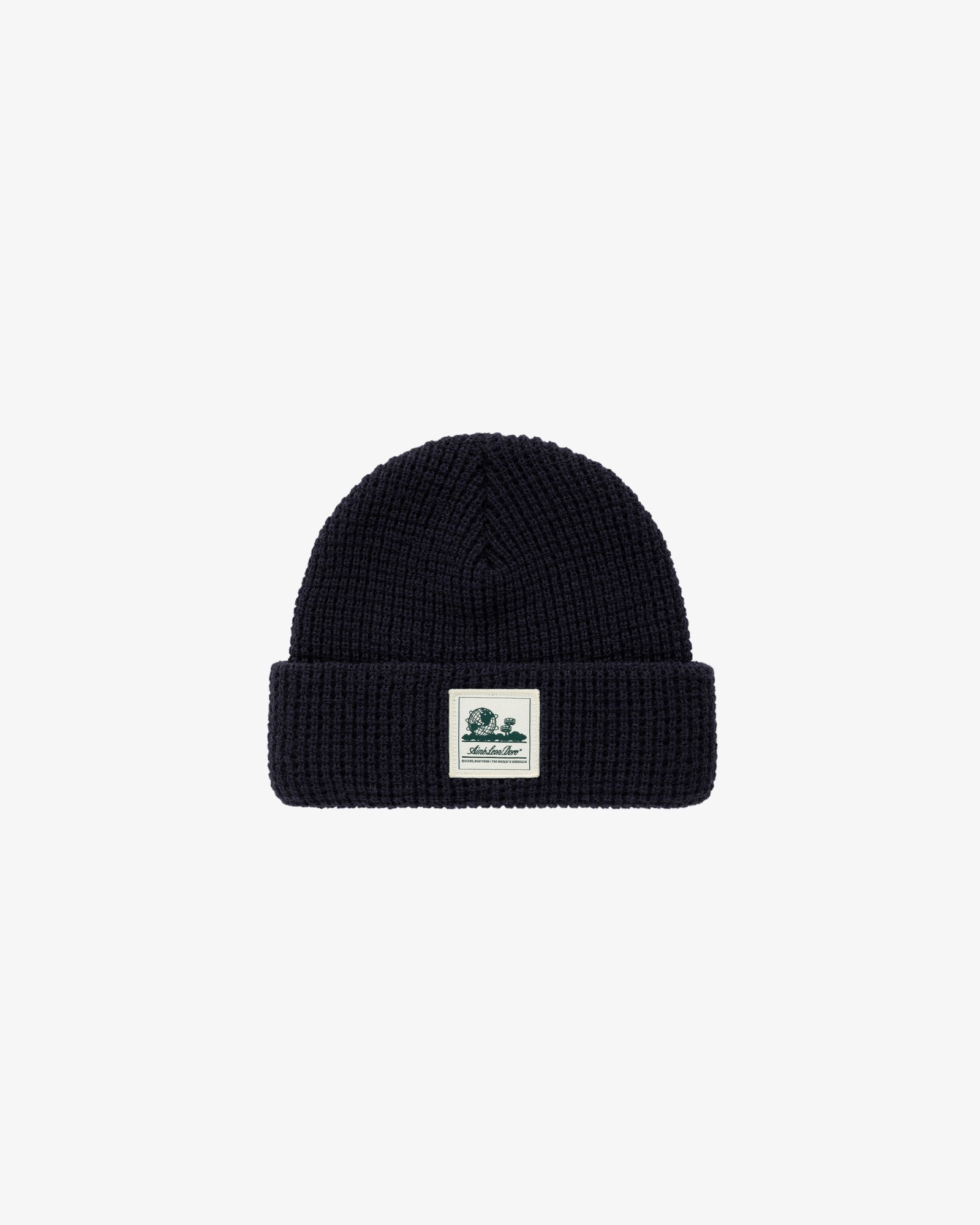 The Waffle Knit Beanie is black with a folded brim and a small logo patch on the front.