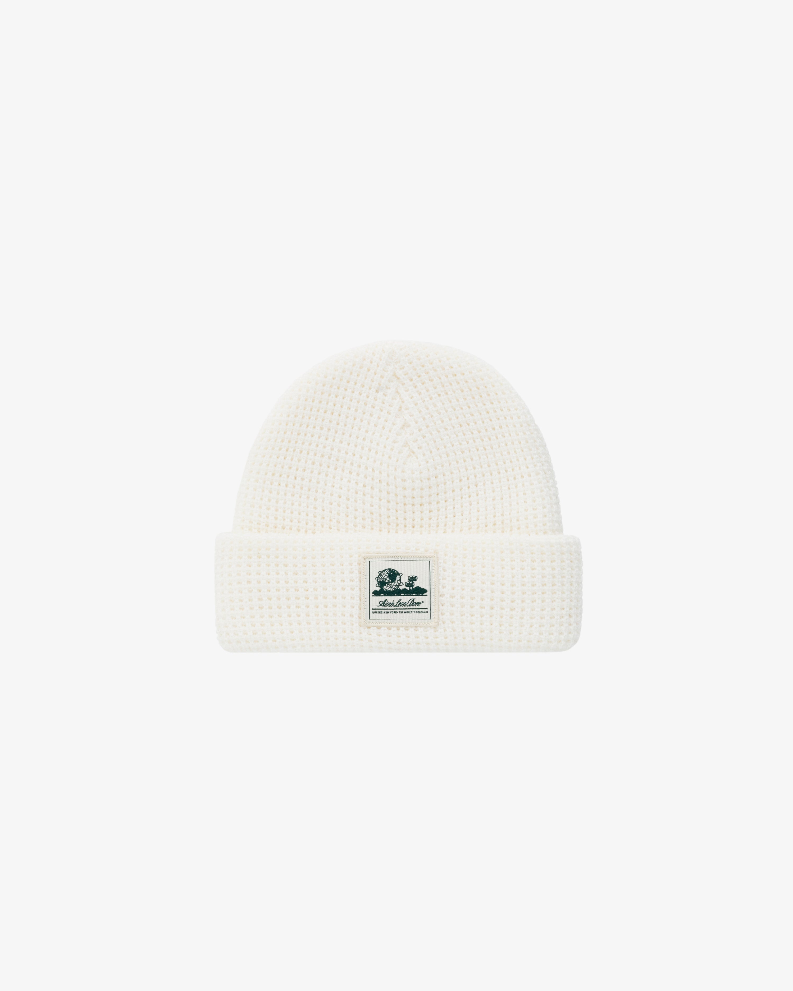 Waffle Knit Beanie in white with folded brim and small green and white logo patch on the front.